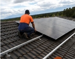 Worker sitting by solar panels